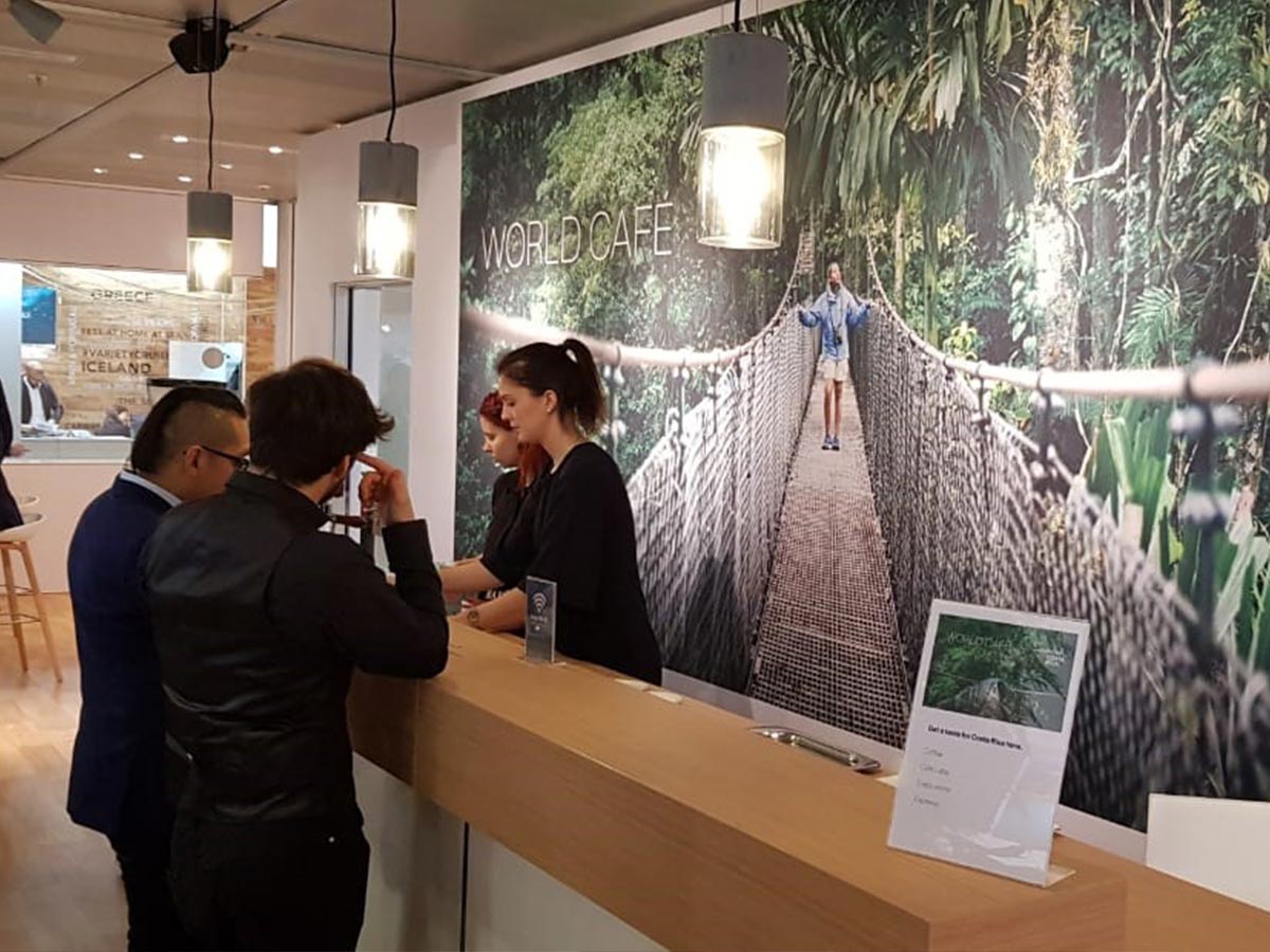 La decoración de la cafetería incluye imágenes de la biodiversidad del bosque nuboso vista desde las alturas con una imponente imagen de un puente colgante sellada con la marca país Esencial Costa Rica.